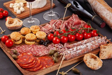 Meze tablo değişik antipasti, peynir, charcuterie, aperatifler ve şarap ile. Mini Burgerler, sosis, jambon, tapas, zeytin, peynir çeşitli kurul ve baget üzerinde gri arka plan beton. Üstten görünüm, düz yatıyordu