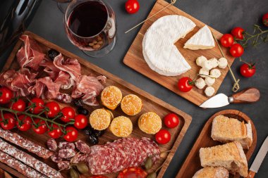 Meze tablo değişik antipasti, peynir, charcuterie, aperatifler ve şarap ile. Mini Burgerler, sosis, jambon, tapas, zeytin, peynir çeşitli kurul ve baget üzerinde gri arka plan beton. Üstten görünüm, düz yatıyordu