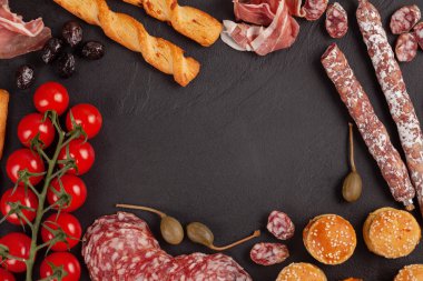 Meze tablo değişik antipasti, peynir, charcuterie, aperatifler ve şarap ile. Mini Burgerler, sosis, jambon, tapas, zeytin, peynir çeşitli kurul ve baget üzerinde gri arka plan beton. Üstten görünüm, düz yatıyordu