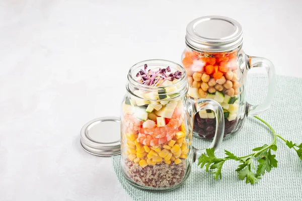 Fresh homemade salad in jars with quinoa, chickpeas  and organic vegetables. Healthy take away food, office lunch, vegeterian, detox diet concept.