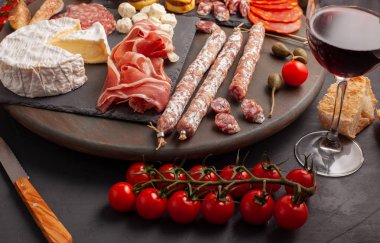 Meze tablo değişik antipasti, peynir, charcuterie, aperatifler ve şarap ile. Mini Burgerler, sosis, jambon, tapas, zeytin, peynir ve baget üzerinde gri arka plan beton. Üstten görünüm, düz yatıyordu