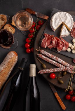 Meze tablo değişik antipasti, peynir, charcuterie, aperatifler ve şarap ile. Mini Burgerler, sosis, jambon, tapas, zeytin, peynir ve baget üzerinde gri arka plan beton. Üstten görünüm, düz yatıyordu
