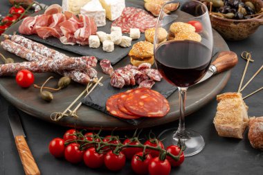 Meze tablo değişik antipasti, peynir, charcuterie, aperatifler ve şarap ile. Mini Burgerler, sosis, jambon, tapas, zeytin, peynir ve baget üzerinde gri arka plan beton. Üstten görünüm, düz yatıyordu
