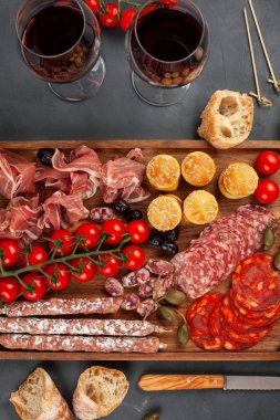 Meze tablo değişik antipasti, peynir, charcuterie, aperatifler ve şarap ile. Mini Burgerler, sosis, jambon, tapas, zeytin, peynir ve baget üzerinde gri arka plan beton. Üstten görünüm, düz yatıyordu