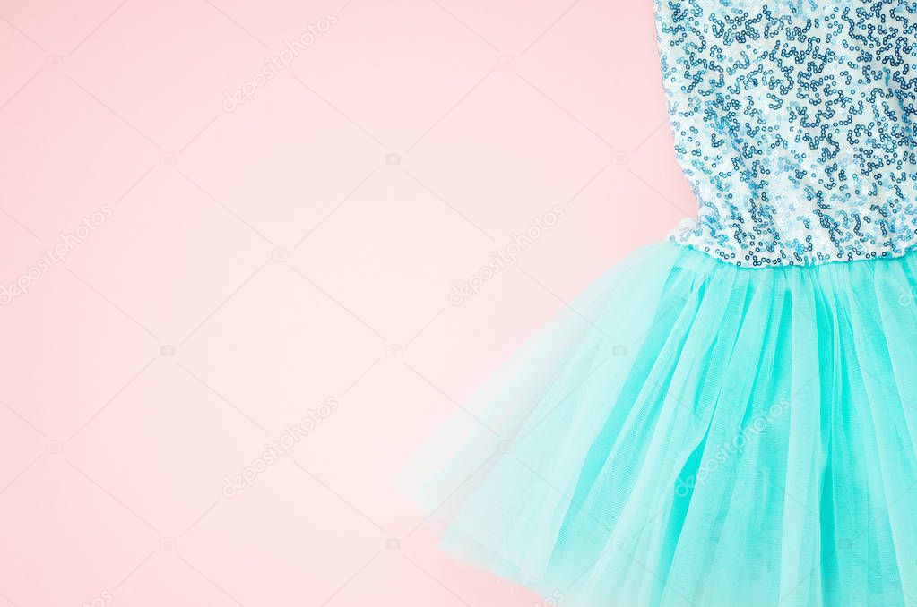 Top view over the girl ballet tutu dress over the pink background. Delicate details of the dress for little princesses
