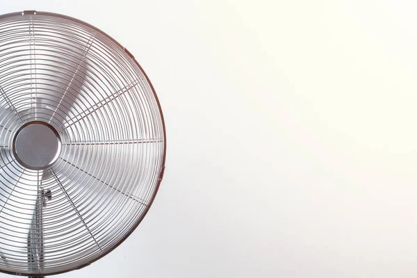 Close up of spinning fan with back sunlit. Copy space Summer heat concept