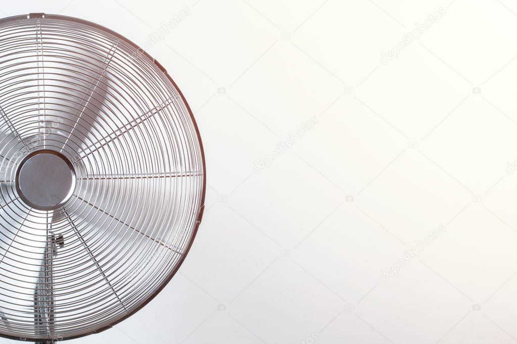 Close up of spinning fan with back sunlit. Copy space Summer heat concept
