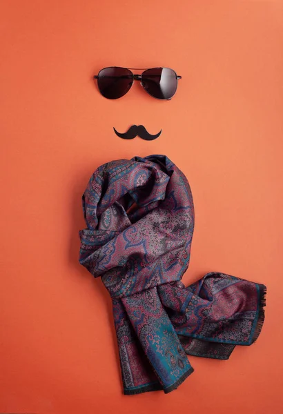 橙色背景带眼镜和围巾的黑色纸胡子 — 图库照片
