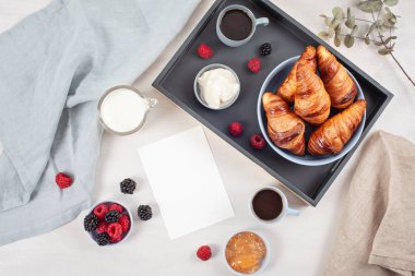Kahve, kruvasan, taze meyveler, süt, krema ve reçel ile kahvaltı
