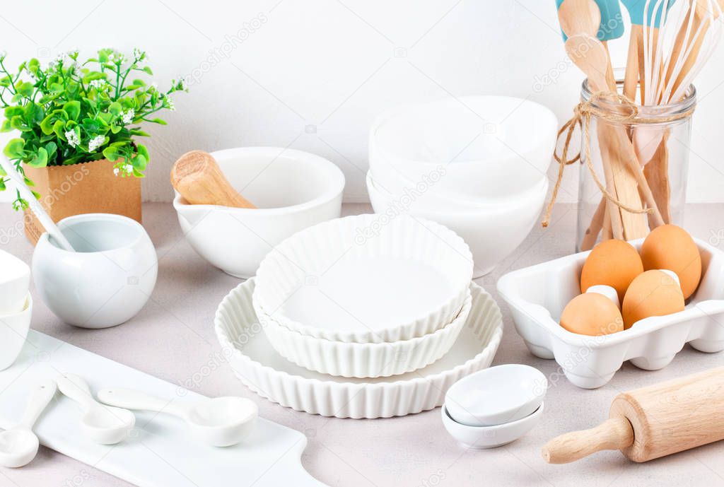Still life with different white bowls, kitchen tools on white table.Various kitchen utensils.