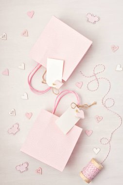 Hediye çanta ve kutu pembe pastel renklerde boş etiketi, kalp ve Noel süslemeleri ile yaratıcı görüntü