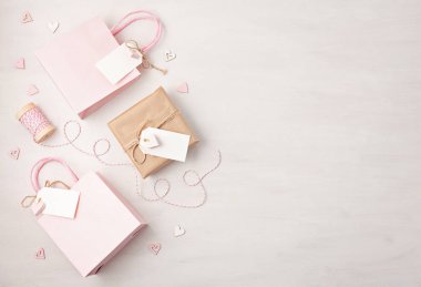 Hediye çanta ve kutu pembe pastel renklerde boş etiketi, kalp ve Noel süslemeleri ile yaratıcı görüntü