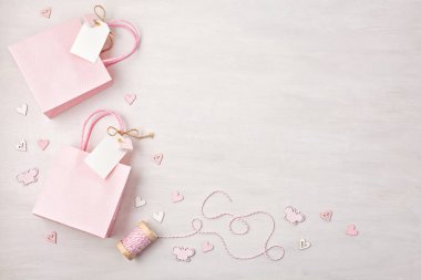 Hediye çanta ve kutu pembe pastel renklerde boş etiketi, kalp ve Noel süslemeleri ile yaratıcı görüntü