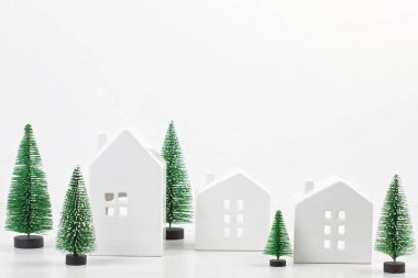 Küçük oyuncak beyaz evler ve Noel süsleri. Boş çerçeve metnin üzerinde mavi pastel renkli kopya alanı ile. Noel kutlamaları fikir