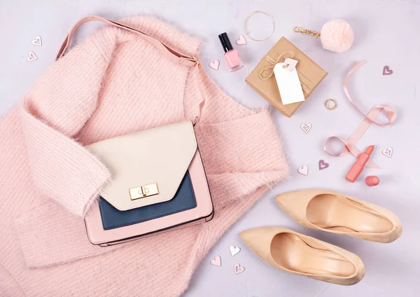 Flat lay of woman clothing and accessories in pastel colors. Modern classic style concept