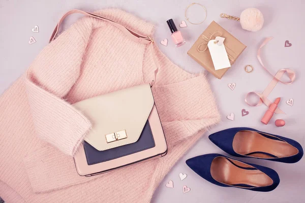 Flat lay of woman clothing and accessories in pastel colors. Modern classic style concept