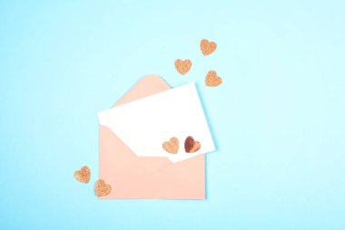 Boş zarf ve kart üzerinde mavi pastel backgroung yürekleri. Aşk, bahar, selamlar dekorasyon 