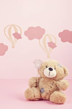 Bulutlar ve ballons ile pembe pastel arka plan üzerinde sevimli oyuncak ayı. Bebek duş, kız doğum günü konsepti