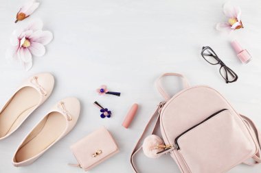 Düz pembe pastel ton kız ilkbahar yaz aksesuarları ile yatıyordu