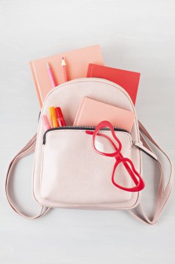 Öğrenci pembe sırt çantası ve çeşitli okul malzemeleri. Studing, eğitim ve geri okul kavramı 