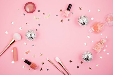 Düz pembe arka plan üzerinde glamour kız aksesuarları ile yatıyordu