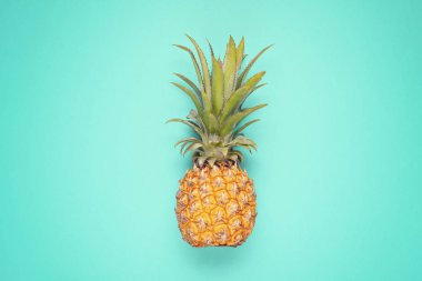 Mavi arka plan üzerinde Tropikal ananas meyve üst görünümü. Yaz tatili, seyahat, turizm konsepti düz yatıyordu. 