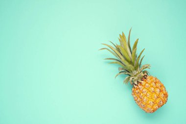 Mavi arka plan üzerinde Tropikal ananas meyve üst görünümü. Yaz tatili, seyahat, turizm konsepti düz yatıyordu. 