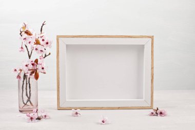 Boş resim çerçevesi ve pembe ihale bahar çiçekleri ile mock up.