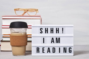 Kitap yığını, metinli ışık kutusu, bir fincan kahve