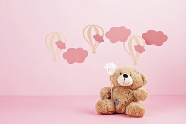 Bulutlar ve ballons ile pembe pastel arka plan üzerinde sevimli oyuncak ayı. Bebek duş, kız doğum günü konsepti