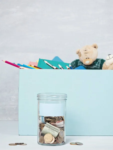 Moedas, notas em frasco de dinheiro e caixa com doações — Fotografia de Stock
