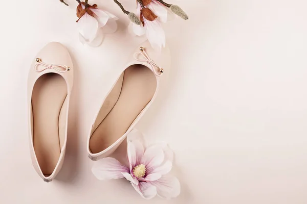 Nude colored ballerina shoes and magnolia flowers.