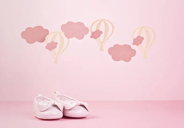 Baby girl cute pink shoes over the pink pastel background with c