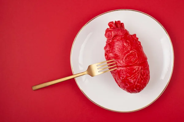 Corazón realista en la mesa de comedor en el plato — Foto de Stock