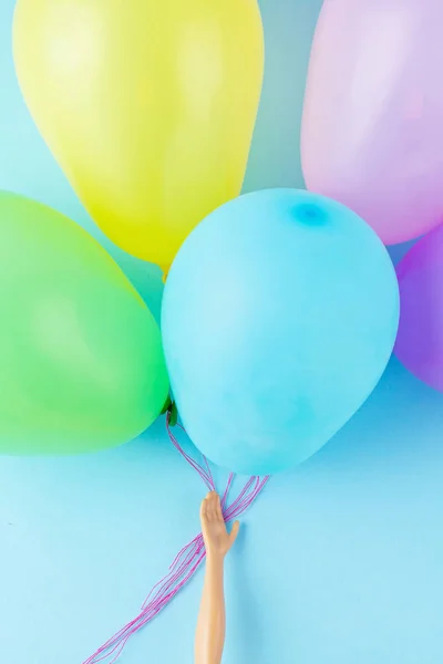 Mano de muñeca sosteniendo globos de colores. Fiesta, celebración, infancia — Foto de Stock