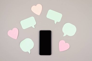 Mockup düz akıllı telefon ve kalpler ve konuşma kabarcıkları ile yatıyordu