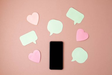 Mockup düz akıllı telefon ve kalpler ve konuşma kabarcıkları ile yatıyordu