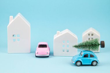 Küçük oyuncak araba çatıda noel ağacı taşıyor. Sessel tatiller, tebrik kartları