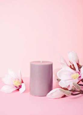 Hassas çiçek kokulu mum pastel pembe arkaplan üzerinde