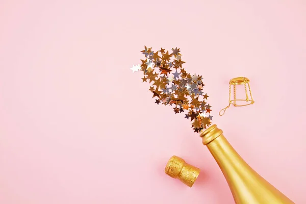 Vista superior Botella dorada de champán y confettie. Fiesta, año nuevo, Navidad, celebración de cumpleaños — Foto de Stock