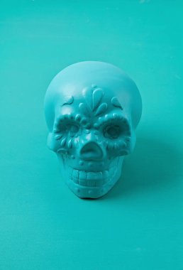 Pastel arka planda turkuaz dekoratif şeker kafatası var. Hal!