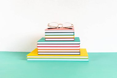 Renkli kitap ve defterler yığını. Eğitim, öğrenim, öğrenme, öğretim kavramı