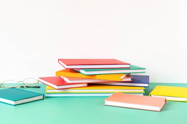 Renkli kitap ve defterler yığını. Eğitim, öğrenim, öğrenme, öğretim kavramı