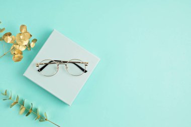 Pastel arka plan üzerinde şık gözlükler. Optik mağaza, gözlük seçimi, göz testi, göz doktorunda vizyon muayenesi moda aksesuarları konsepti. Üst manzara, düz uzanma