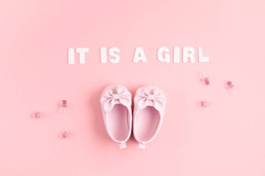 Yeni doğmuş şirin bebek ayakkabıları ve pembe arka planda şenlik süsleri. Bebek partisi, doğum günü, davetiye ya da tebrik kartı fikri