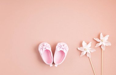 Yeni doğmuş şirin bebek ayakkabıları ve pembe arka planda şenlik süsleri. Bebek partisi, doğum günü, davetiye ya da tebrik kartı fikri