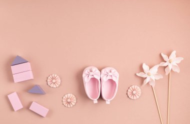 Yeni doğmuş şirin bebek ayakkabıları ve pembe arka planda şenlik süsleri. Bebek partisi, doğum günü, davetiye ya da tebrik kartı fikri