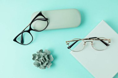 Pastel arka plan üzerinde şık gözlükler. Optik mağaza, gözlük seçimi, göz testi, göz doktorunda vizyon muayenesi moda aksesuarları konsepti. Üst manzara, düz uzanma