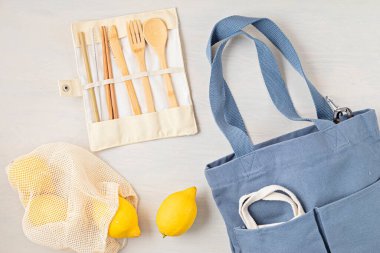 Sıfır atık. Çevre dostu bambu çatal bıçak takımı, ağ pamuk torbası, yeniden kullanılabilir kahve bardağı, fırçalar ve su şişesi. Sürdürülebilir, etik, plastik içermeyen konsept