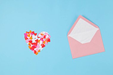 Kalp konfetisi ve pembe zarf. Aşk, sevgililer günü, anneler günü tebrik kartı, minnettarlık, doktorlar ve hemşireler konseptine şükranlarını sunmak.